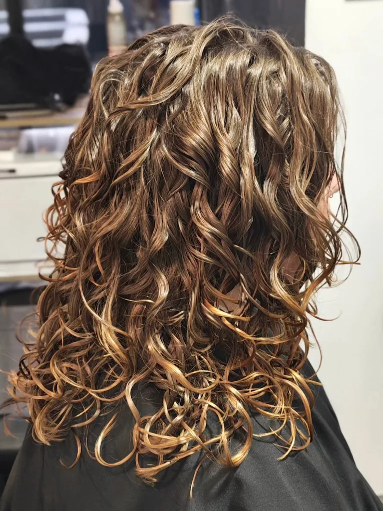 Long curly hair with honey balayage highlights and defined natural curls after a Roò curly cut at True Hair Collective Sydney CBD